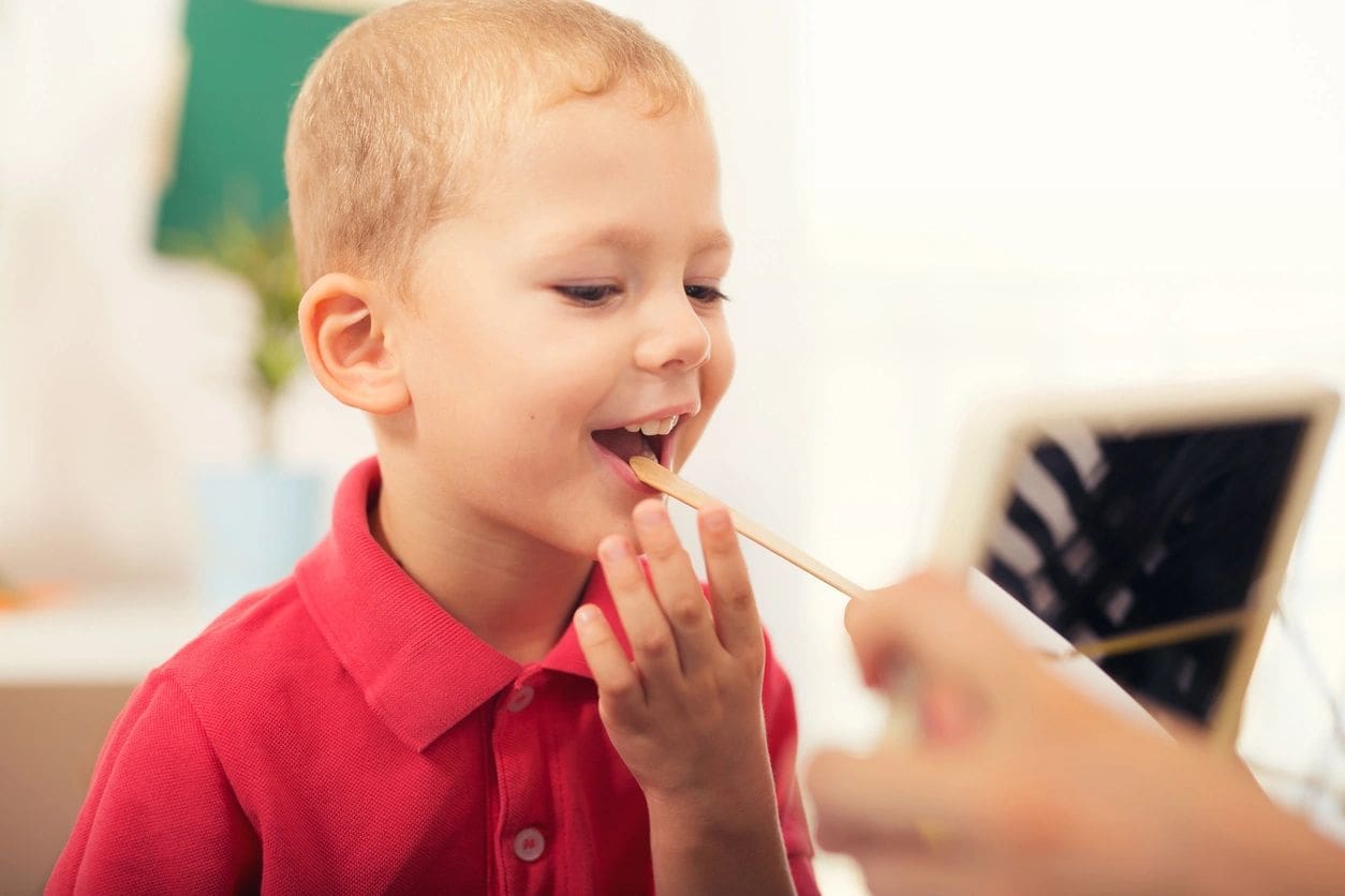 Little boy during lesson with his speech therapist. Learning through fun and play